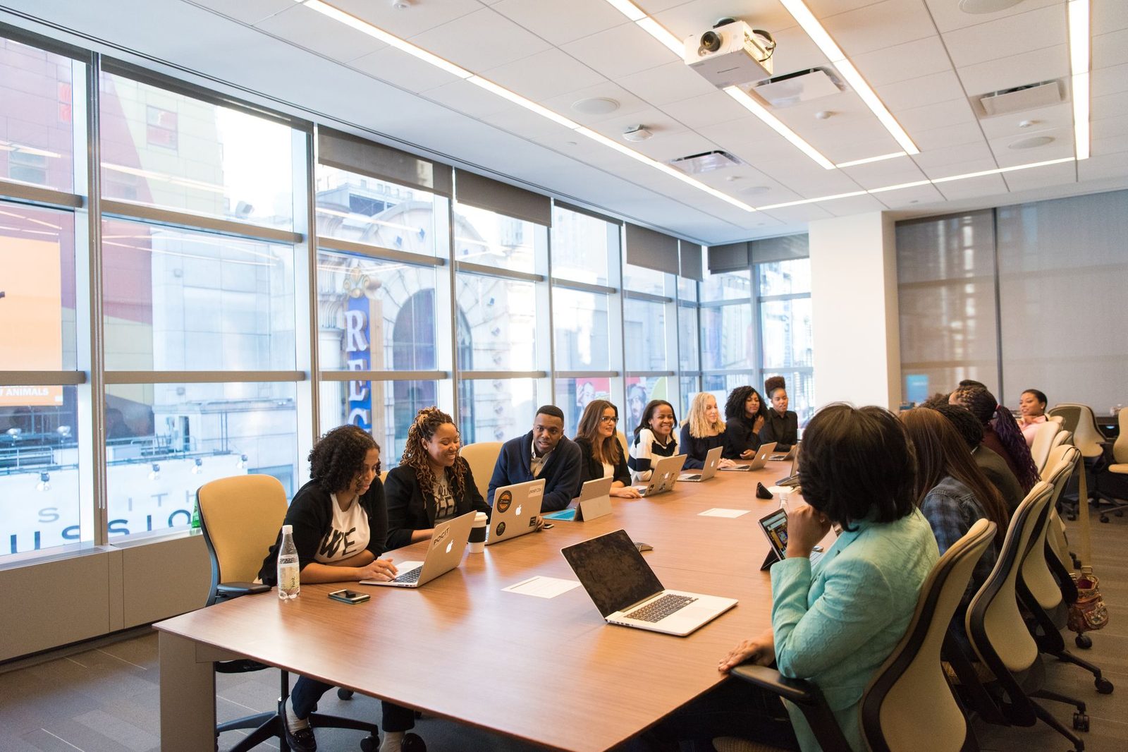 A team gathered around a conference table with laptops and notes, working through an event plan together