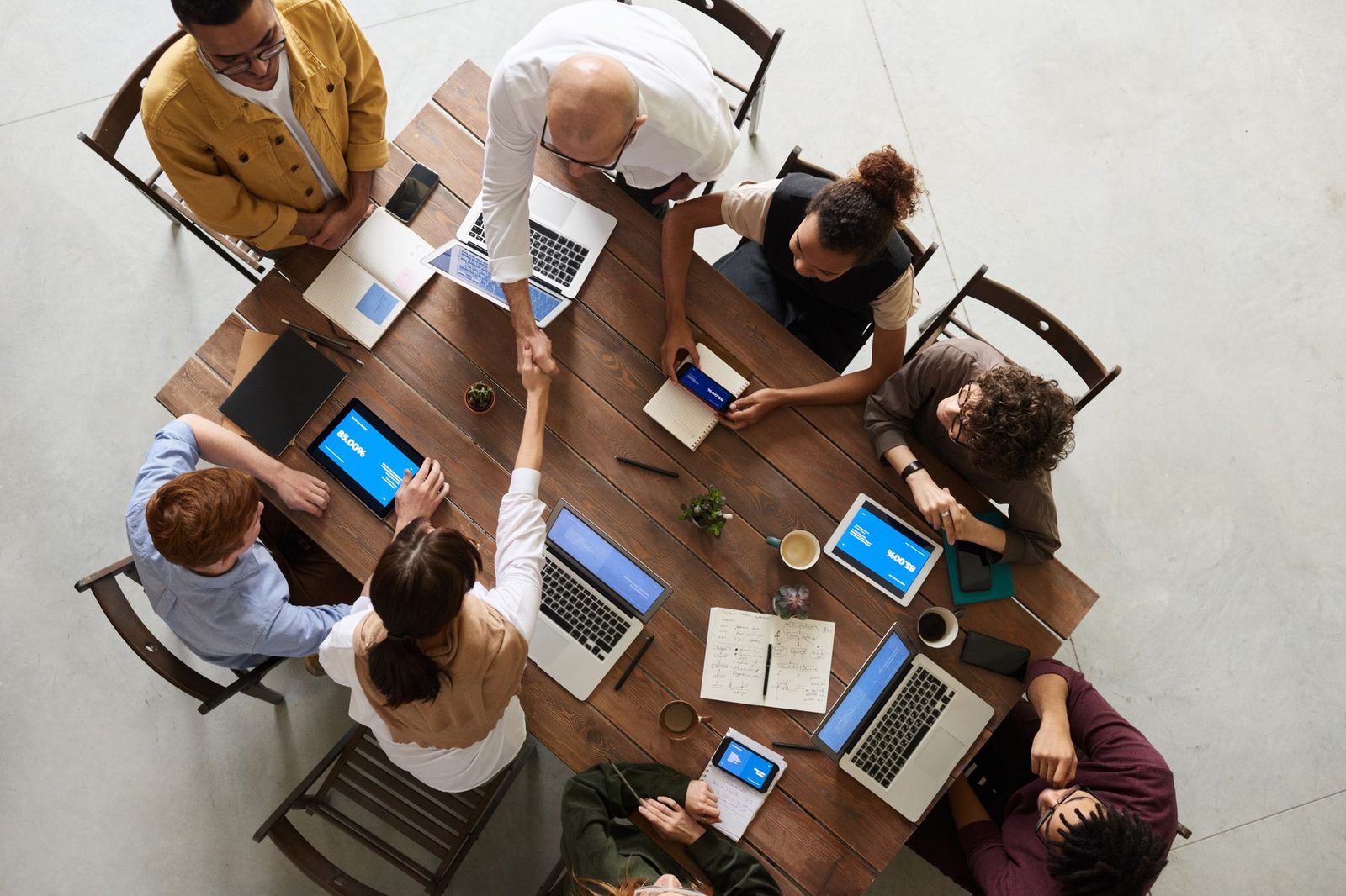 A team seated around a table with laptops and notes, planning together in a bright room