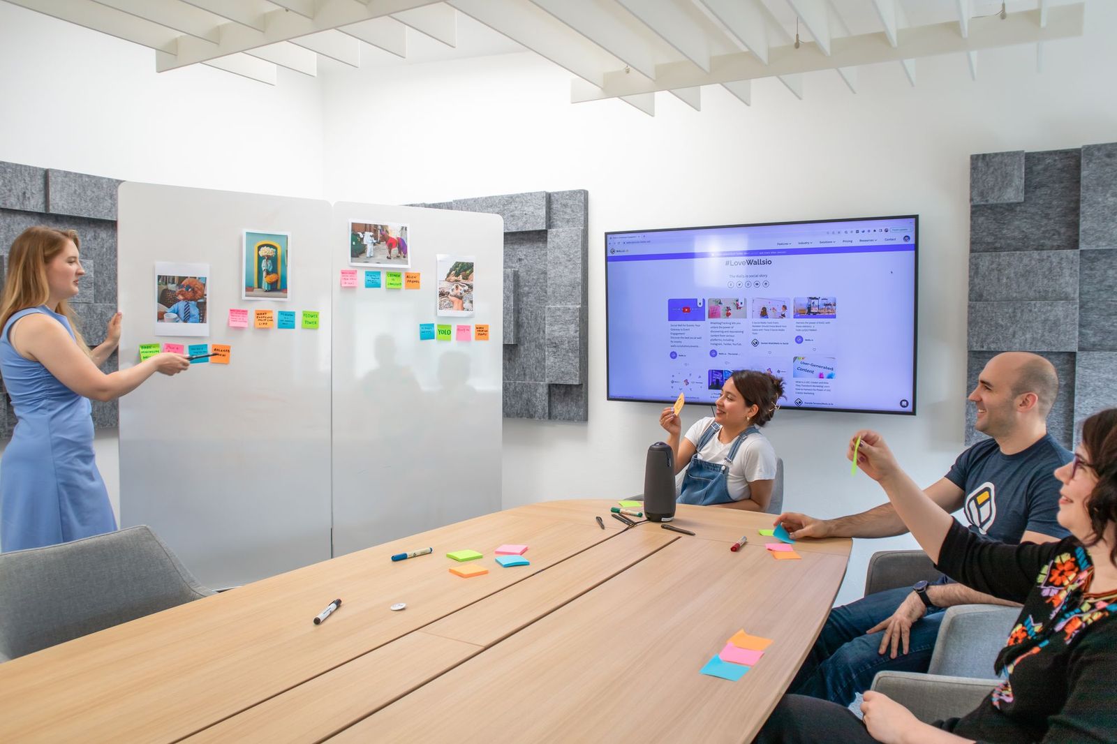A small team gathered around a laptop reviewing printed charts and spreadsheets spread across a table